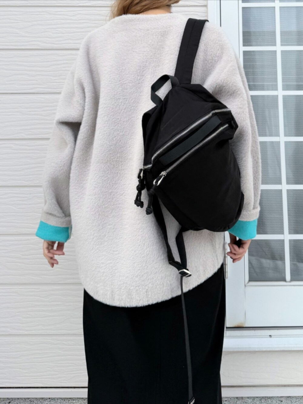 ブラック系のスカート、ベージュ系のカーディガン/ボレロ、ブラック系のTシャツ/カットソーを着用したレディースの秋コーディネートの5枚目の写真