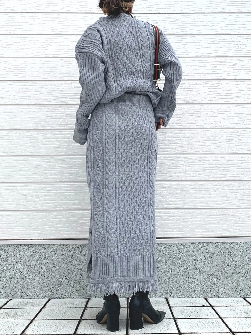 ブラック系のショルダーバッグ、グレー系のスカート、グレー系のニット/セーターを着用したレディースの冬コーディネートの3枚目の写真