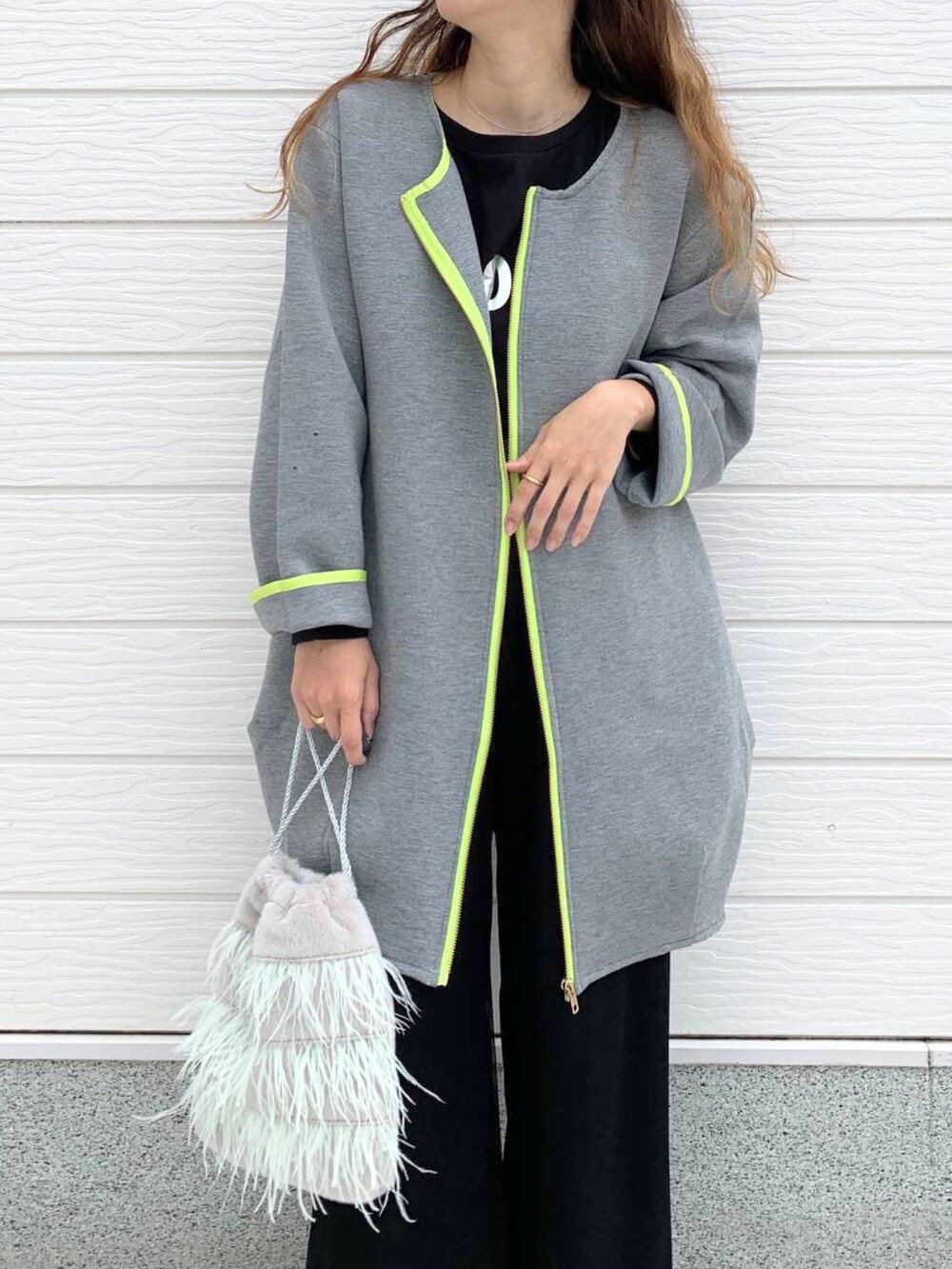 グレー系のクラッチバッグ、ホワイト系のスニーカー、ブラック系のTシャツ/カットソーを着用したレディースの秋コーディネートの2枚目の写真