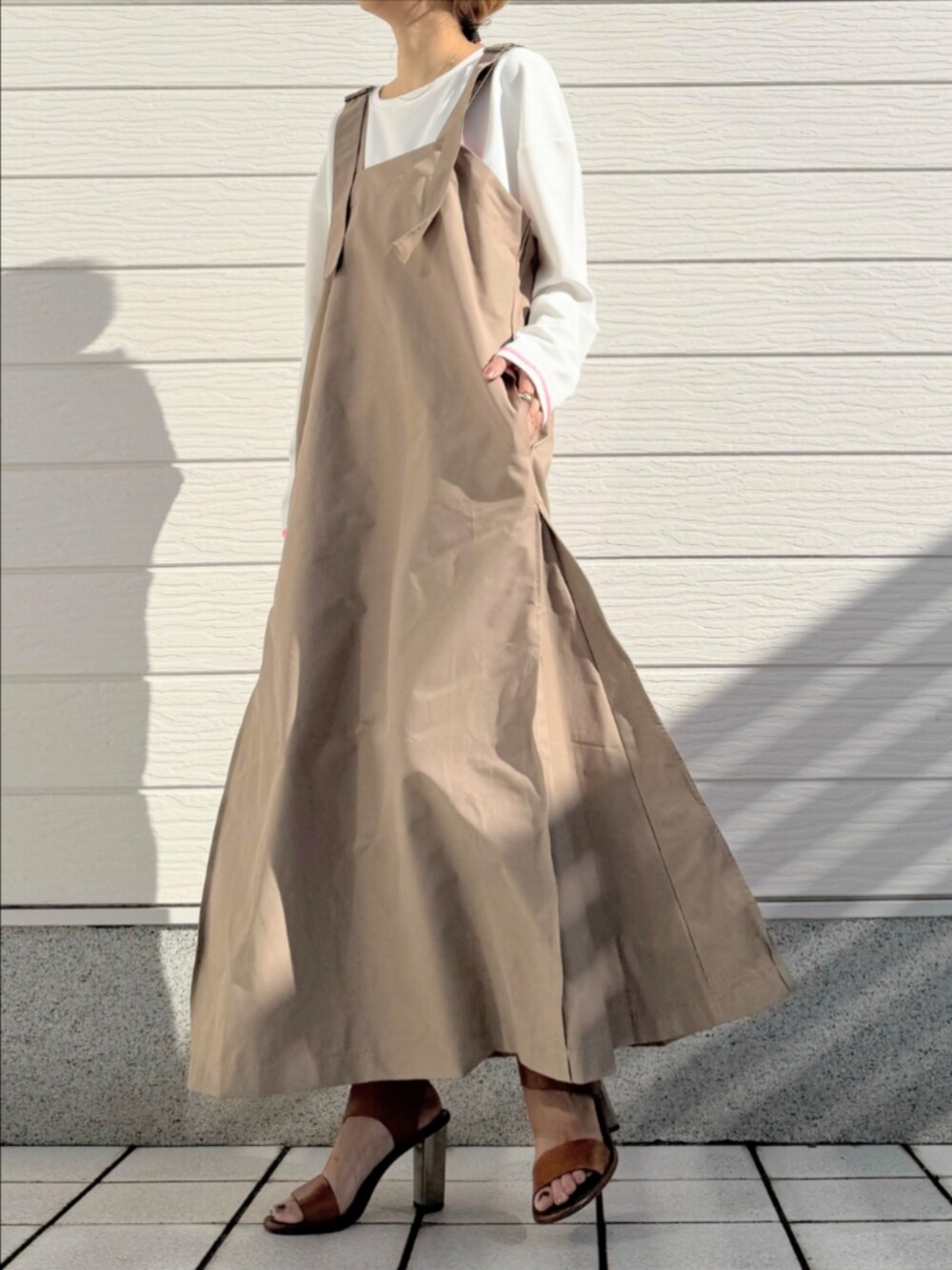 ブラウン系のサンダル、ホワイト系のTシャツ/カットソー、ベージュ系のワンピースを着用したレディースの冬コーディネートの2枚目の写真