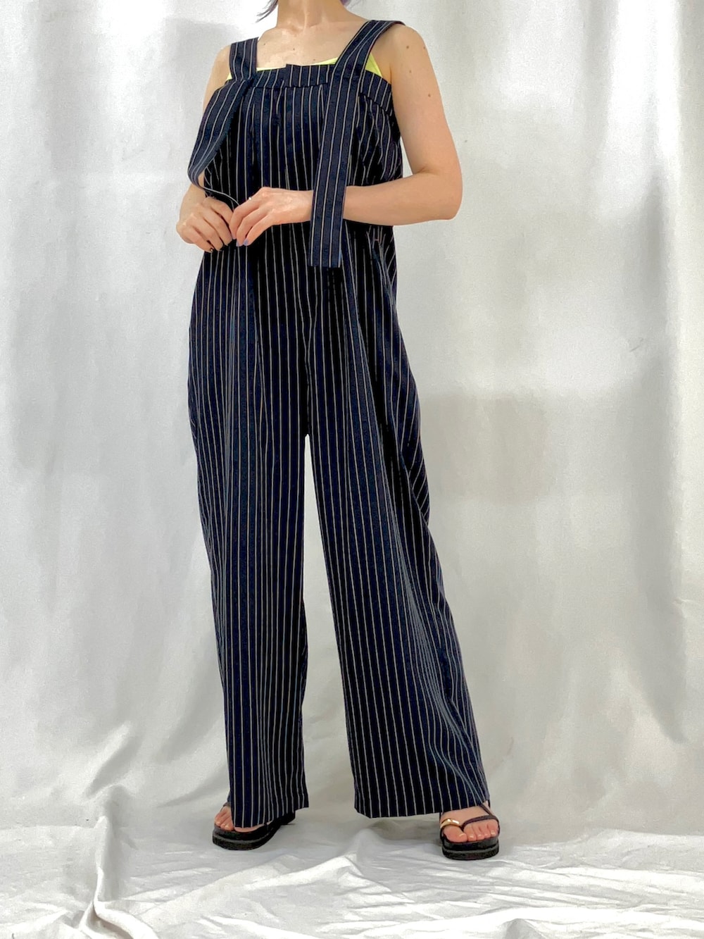 ベージュ系のブルゾン、ブルー系のサロペット/オーバーオール、ブラック系のサンダルを着用したレディースの春コーディネートの4枚目の写真