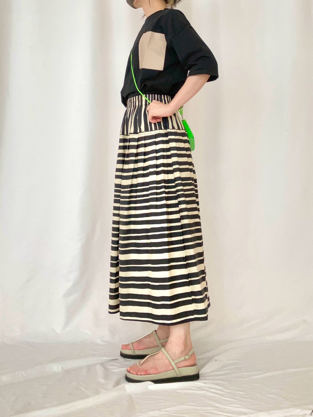 ブラック系のTシャツ/カットソー、グレー系のサンダル、ブラック系のスカートを着用したレディースの夏コーディネートの2枚目の写真