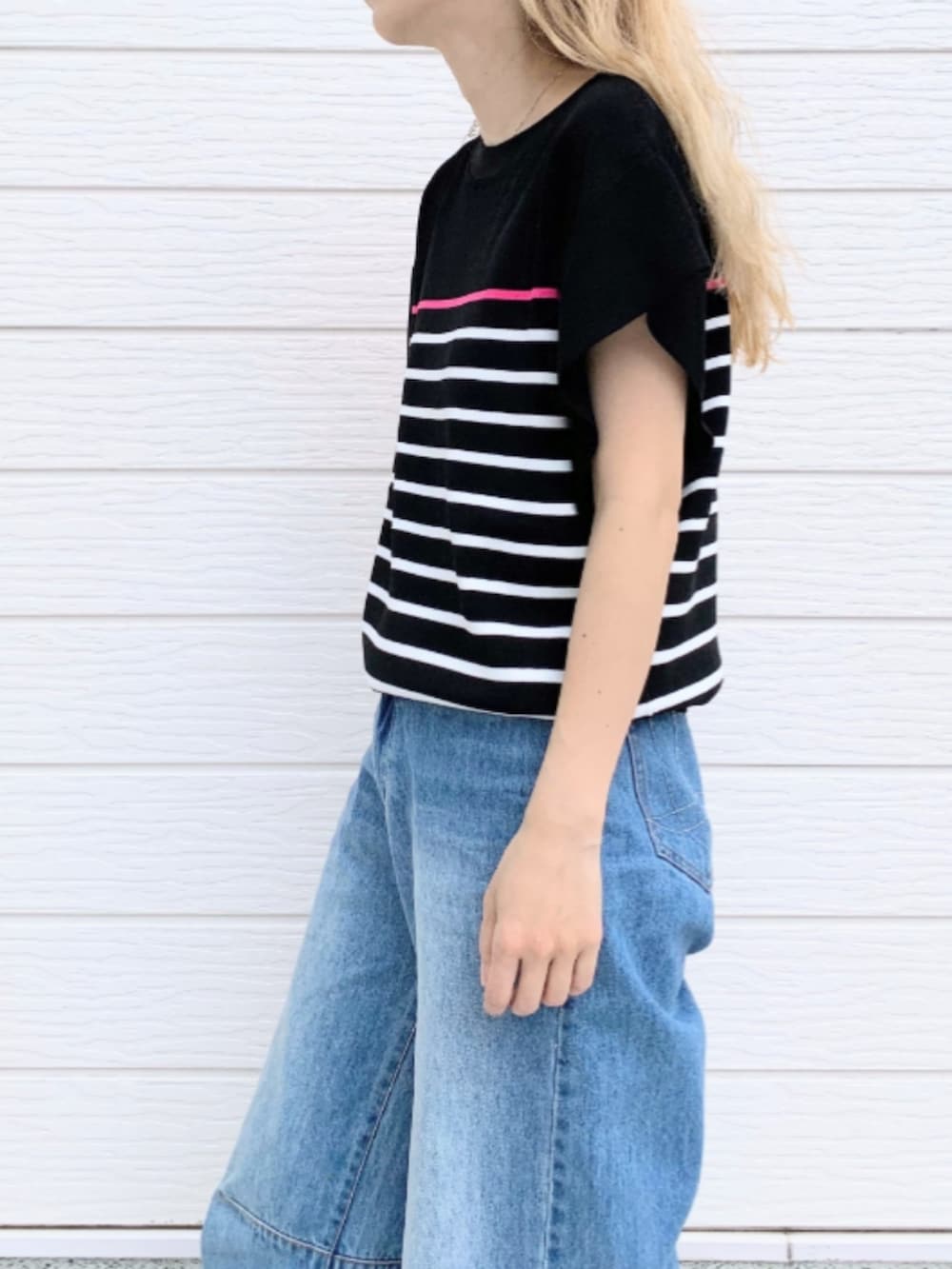 ブルー系のトートバッグ、ブルー系のデニムパンツ、ブラック系のニット/セーターを着用したレディースの春コーディネートの5枚目の写真