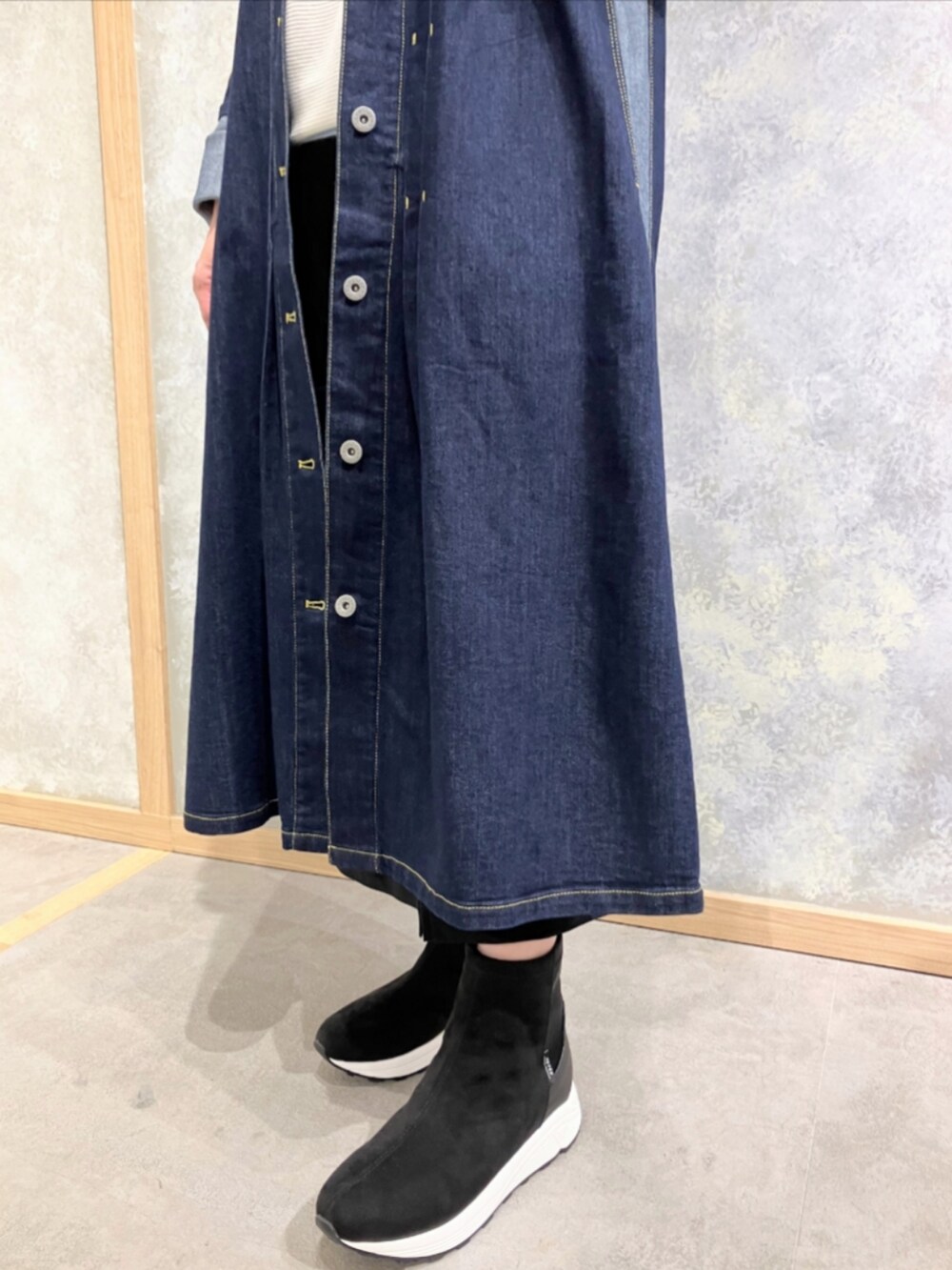 グレー系のブーツ、ブルー系のデニムジャケット、ブラック系のスカートを着用したレディースの秋コーディネートの5枚目の写真