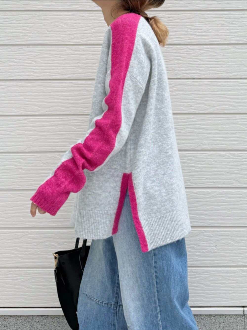 ブルー系のデニムパンツ、ブラック系のトートバッグ、グレー系のニット/セーターを着用したレディースの冬コーディネートの4枚目の写真