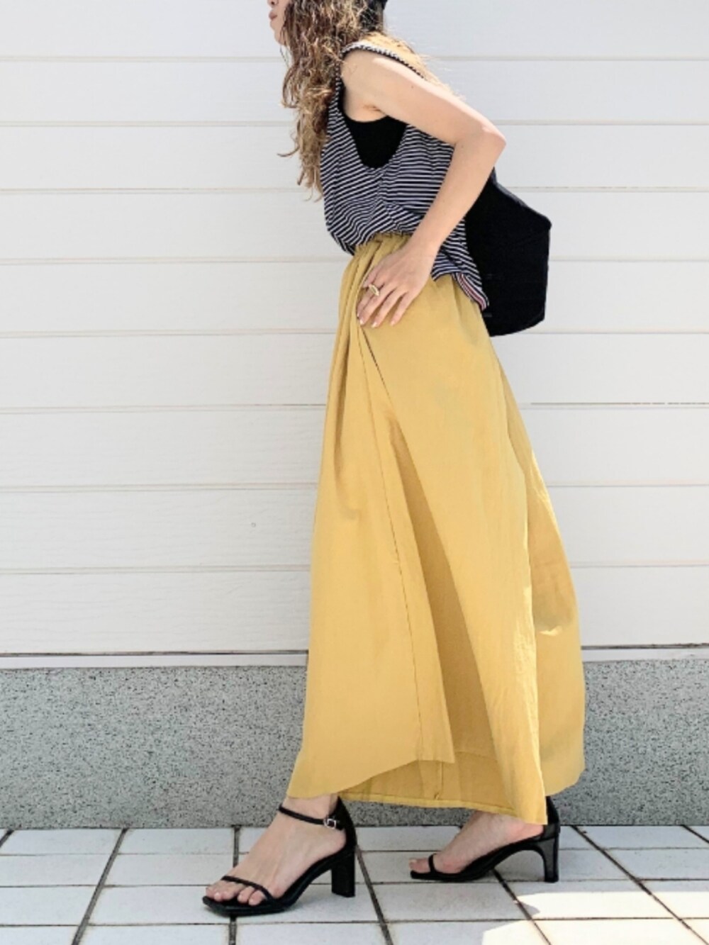 ブラック系のTシャツ/カットソー、ブラック系のトートバッグ、イエロー系のその他パンツを着用したレディースの夏コーディネートの3枚目の写真