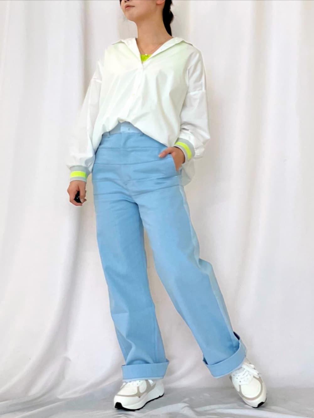 ブルー系のデニムパンツ、ホワイト系のスニーカー、ホワイト系のシャツ/ブラウスを着用したレディースの春コーディネートの3枚目の写真