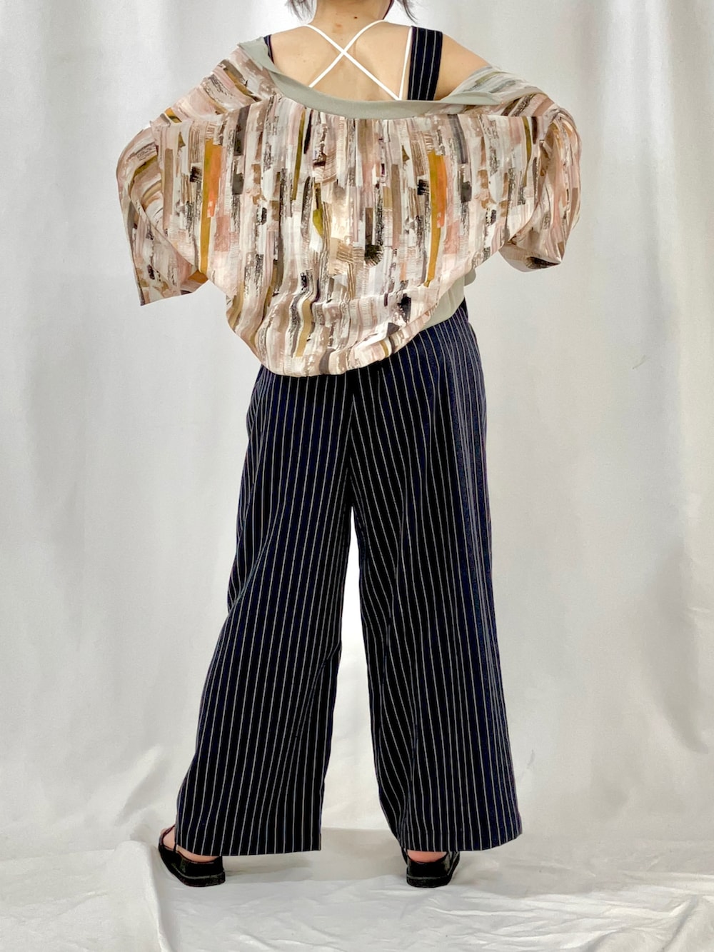 ベージュ系のブルゾン、ブルー系のサロペット/オーバーオール、ブラック系のサンダルを着用したレディースの春コーディネートの3枚目の写真