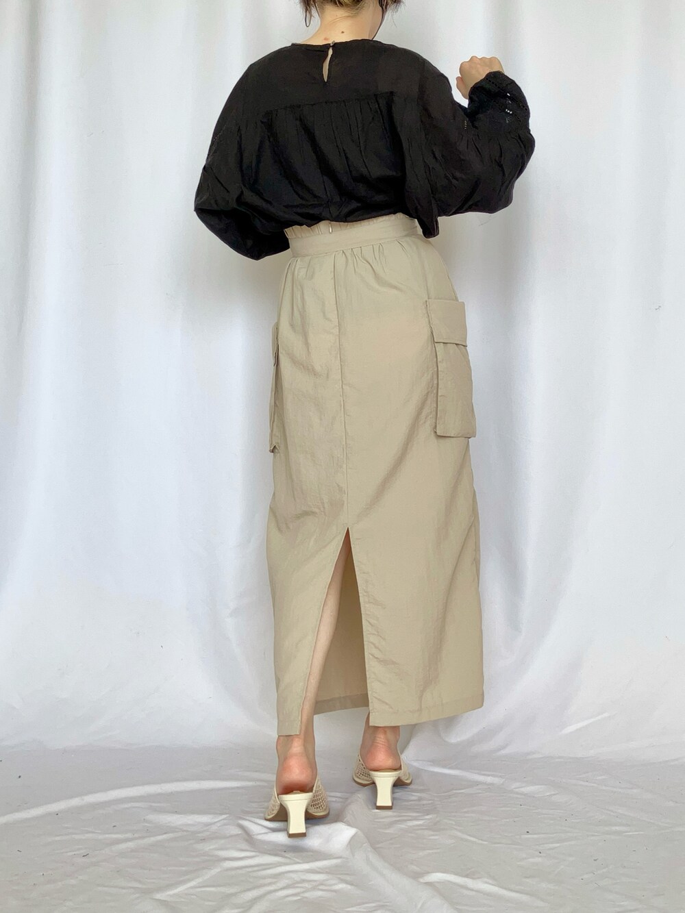 ブラック系のシャツ/ブラウス、ベージュ系のスカート、グレー系のサンダルを着用したレディースの夏コーディネートの5枚目の写真