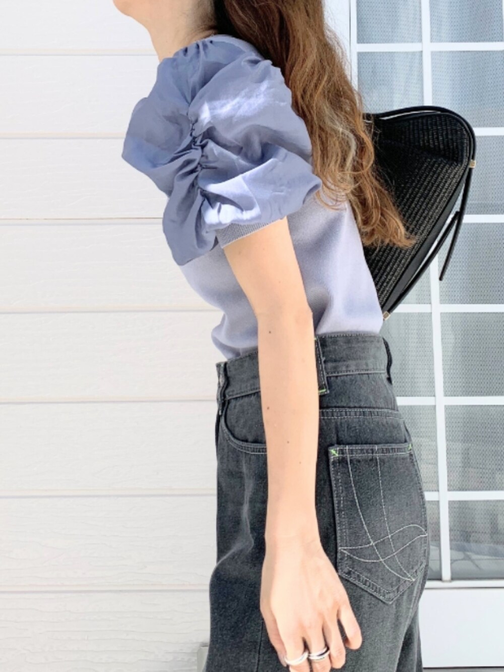 グレー系のデニムパンツ、ブラック系のショルダーバッグ、ブルー系のニット/セーターを着用したレディースの春コーディネートの5枚目の写真