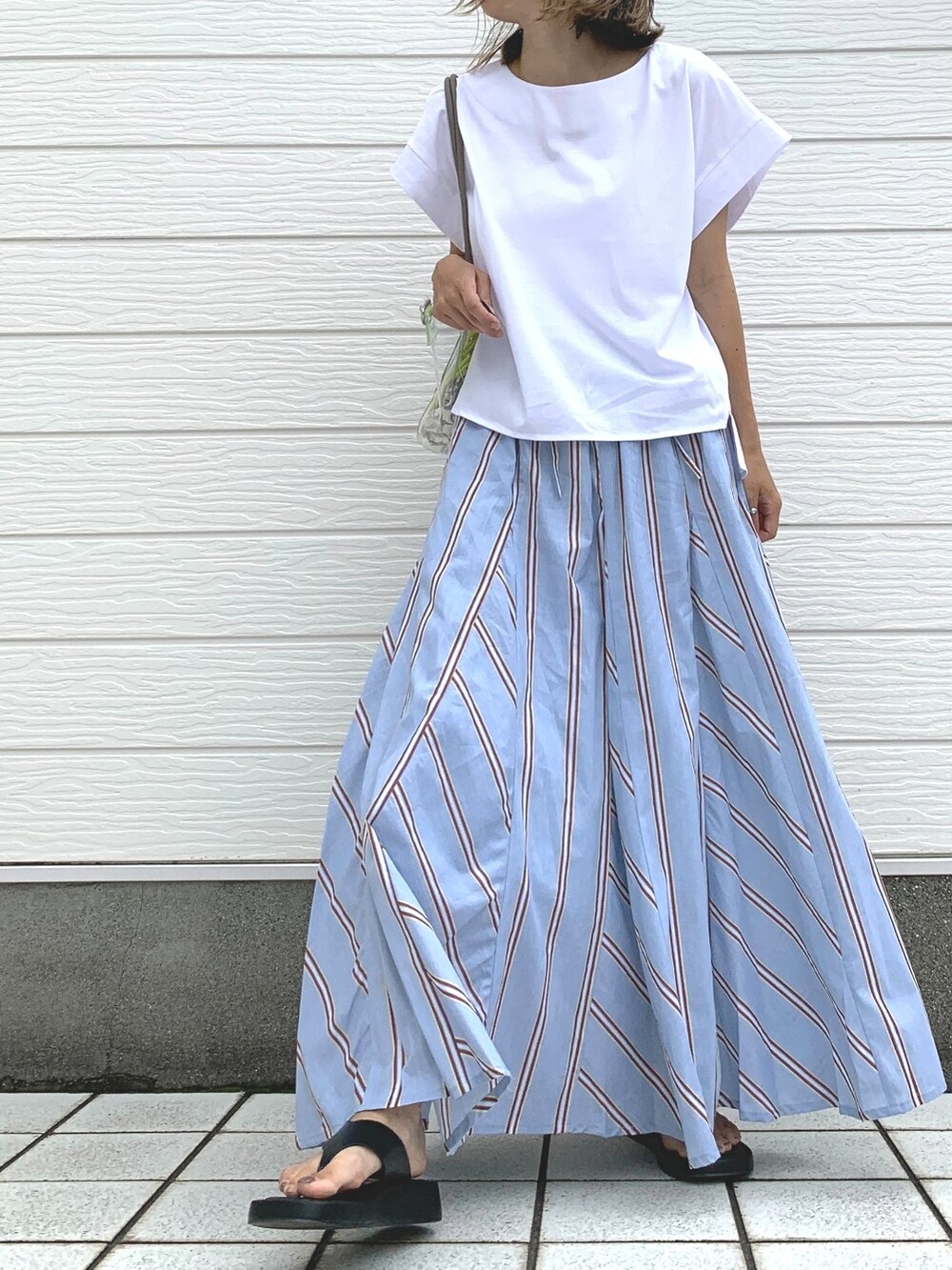 ホワイト系のTシャツ/カットソー、グリーン系のトートバッグ、ブルー系のスカートを着用したレディースの夏コーディネートの2枚目の写真