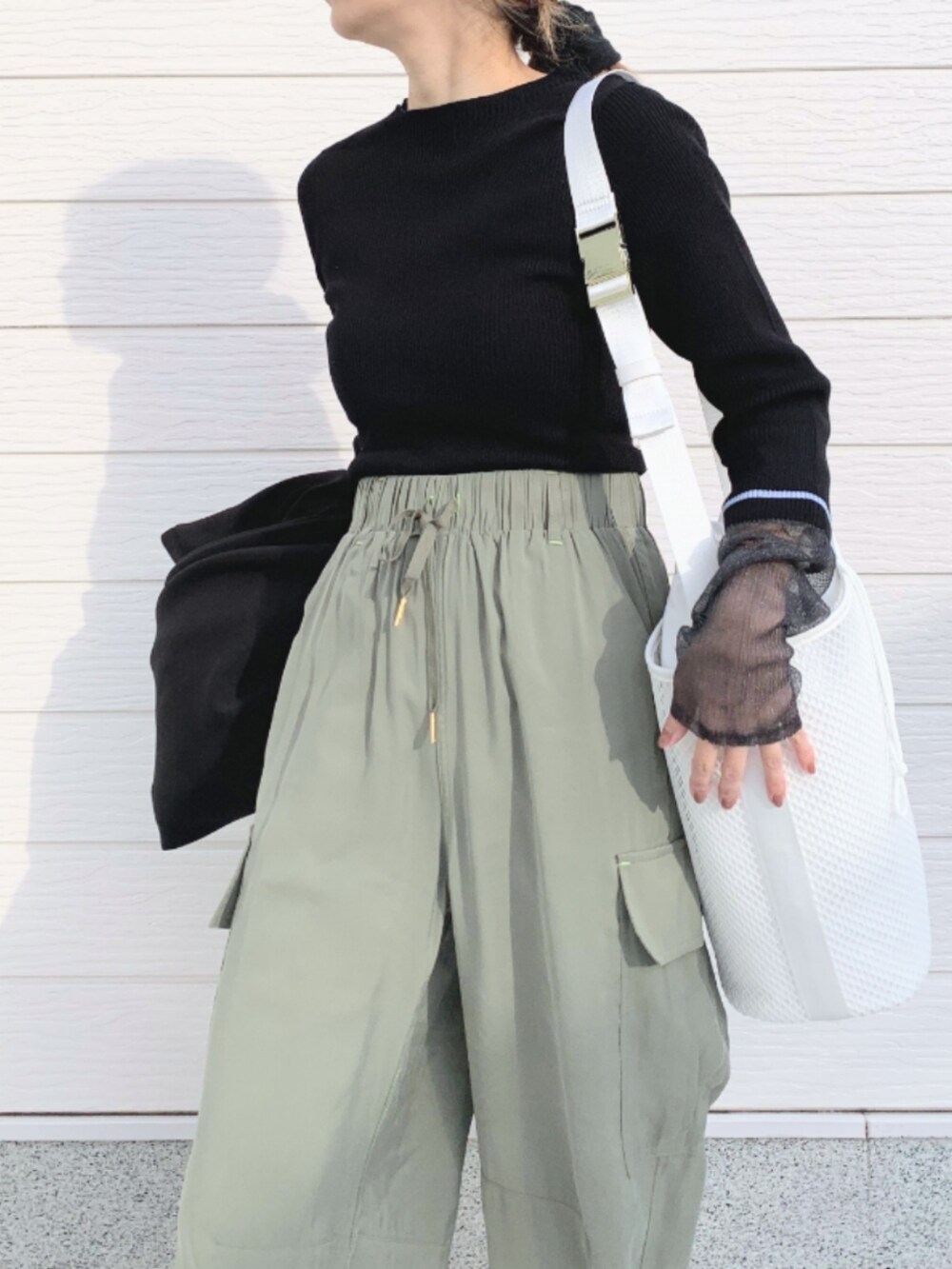 ブラック系のその他アウター、ホワイト系のショルダーバッグ、ブラック系のニット/セーターを着用したレディースの冬コーディネートの5枚目の写真