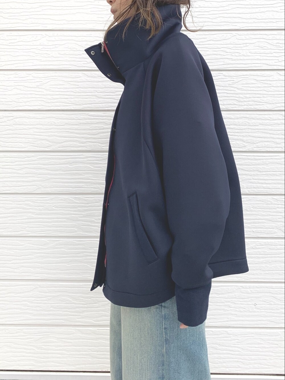 ブルー系のデニムパンツ、ホワイト系のショルダーバッグ、ブルー系のブルゾンを着用したレディースの冬コーディネートの4枚目の写真