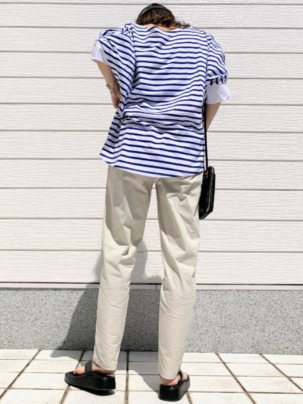 ホワイト系のその他パンツ、ブルー系のTシャツ/カットソー、ブラック系のショルダーバッグを着用したレディースの春コーディネートの2枚目の写真