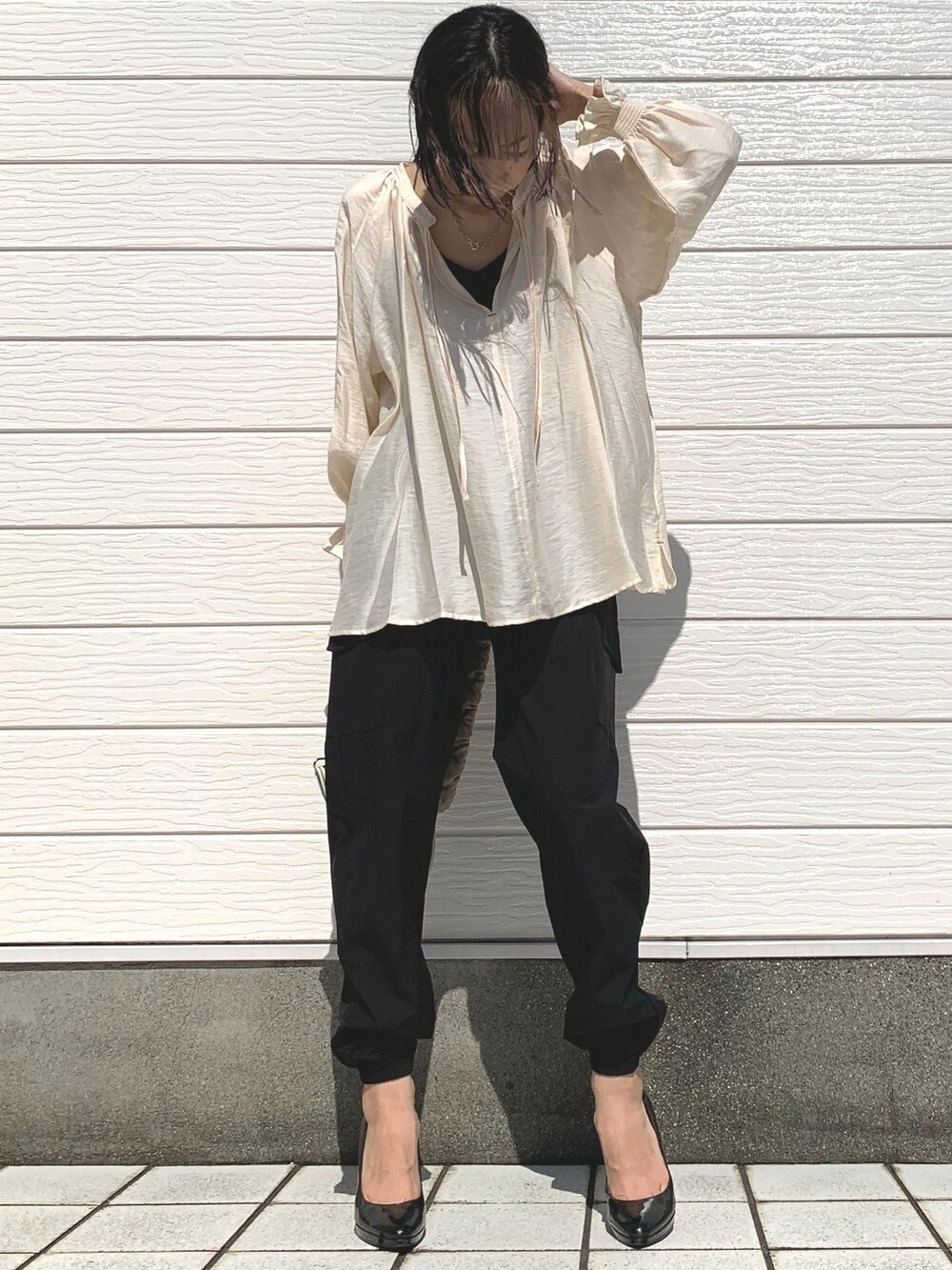 ベージュ系のショルダーバッグ、ホワイト系のシャツ/ブラウス、ブラック系のカーゴパンツを着用したレディースの夏コーディネートの3枚目の写真