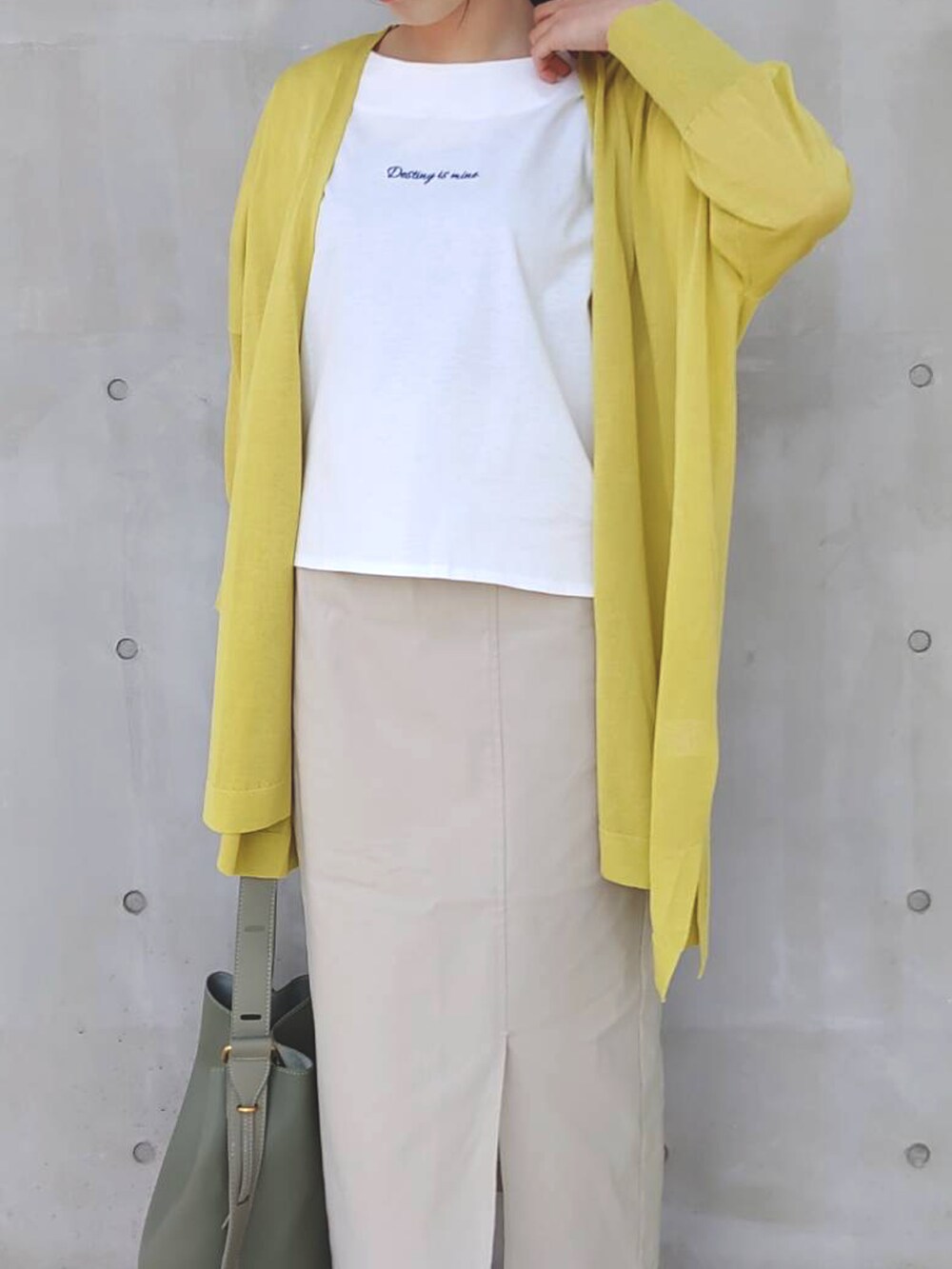 ホワイト系のTシャツ/カットソー、イエロー系のカーディガン/ボレロ、ベージュ系のスカートを着用したレディースの春コーディネートの3枚目の写真