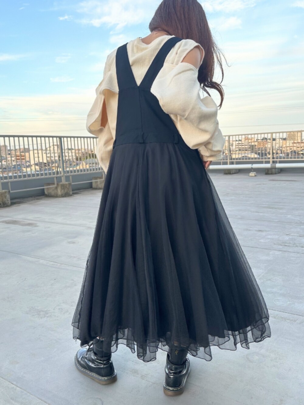 ホワイト系のTシャツ/カットソー、ブラック系のジャンパースカートを着用したレディースの秋コーディネートの3枚目の写真