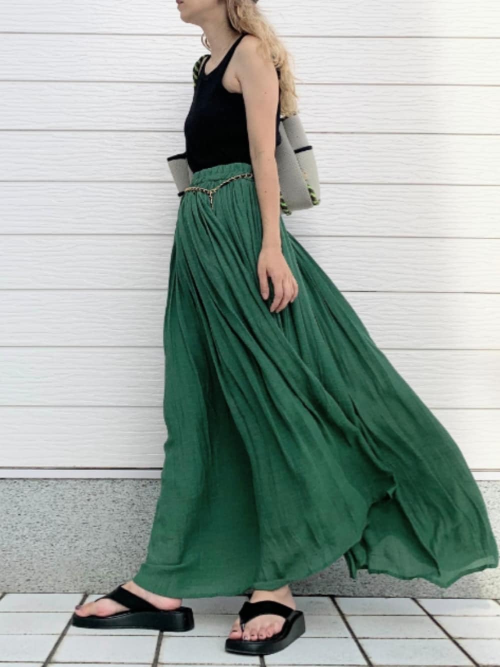 グレー系のトートバッグ、ブラック系のタンクトップ、グリーン系のスカートを着用したレディースの夏コーディネートの2枚目の写真