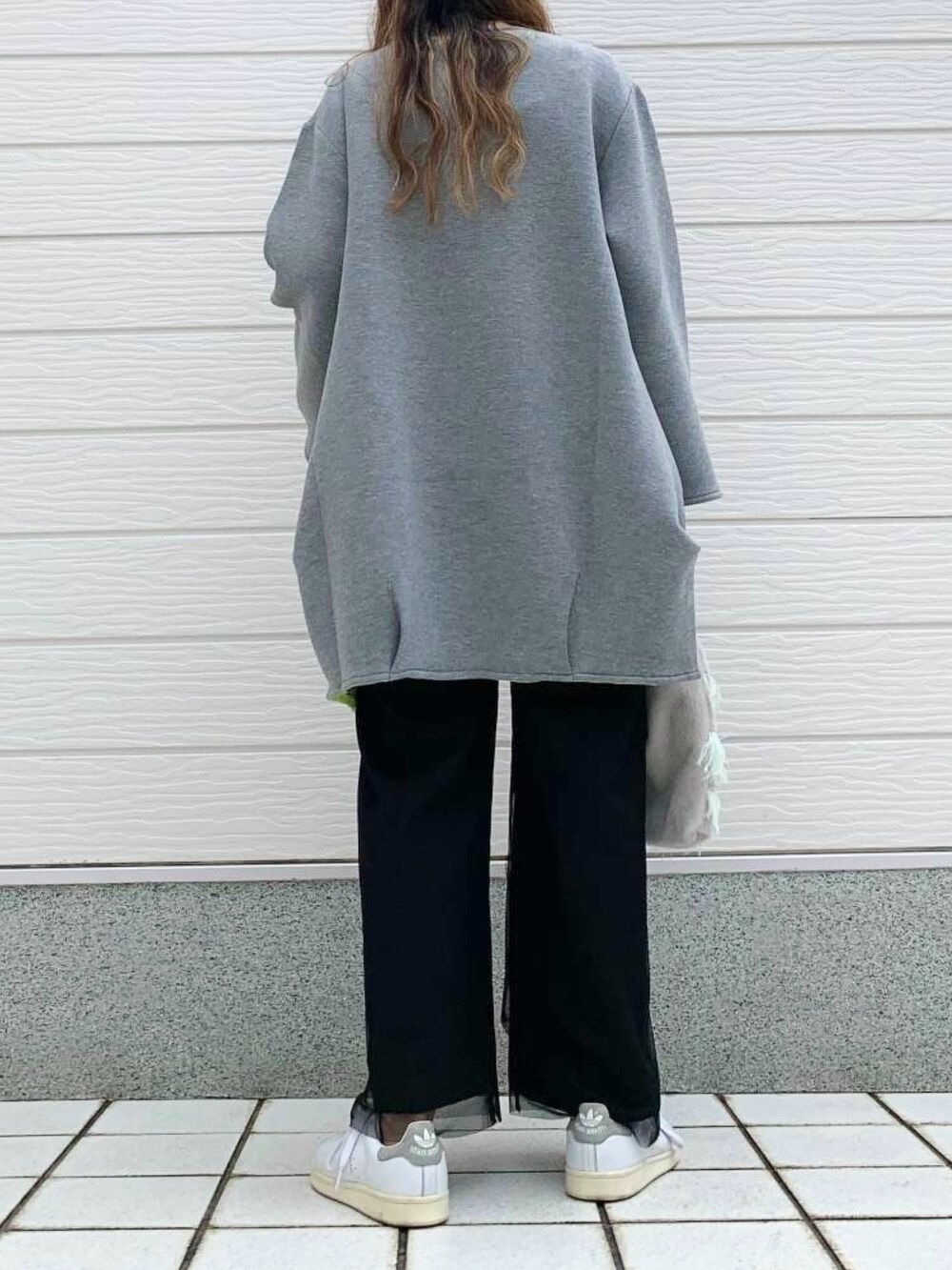 グレー系のクラッチバッグ、ホワイト系のスニーカー、ブラック系のTシャツ/カットソーを着用したレディースの秋コーディネートの5枚目の写真