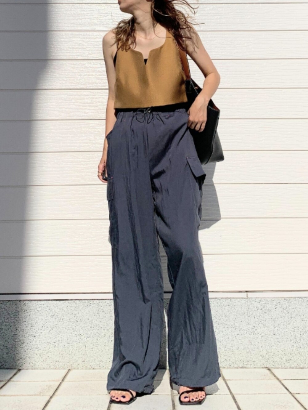 グレー系のその他パンツ、イエロー系のベスト、ブラック系のショルダーバッグを着用したレディースの夏コーディネートの2枚目の写真