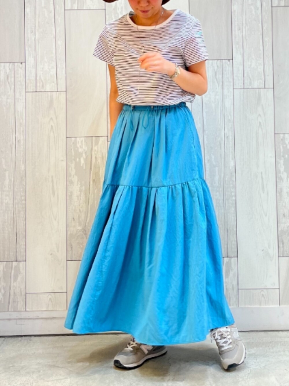 ホワイト系のTシャツ/カットソー、ブルー系のスカート、ブラウン系のハットを着用したレディースの春コーディネートの2枚目の写真