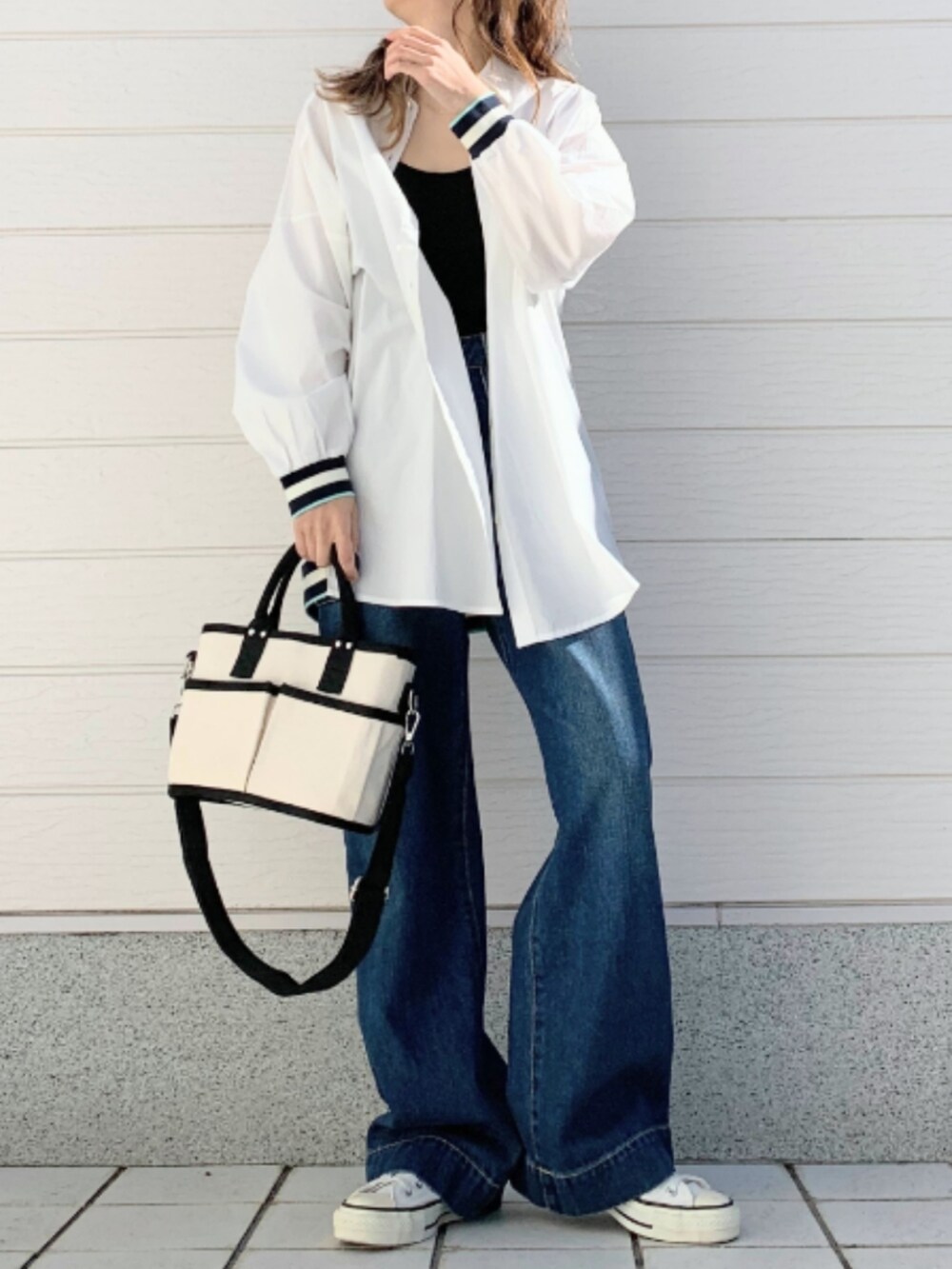 ブルー系のデニムパンツ、ホワイト系のシャツ/ブラウス、ブラック系のキャミソールを着用したレディースの冬コーディネートの2枚目の写真