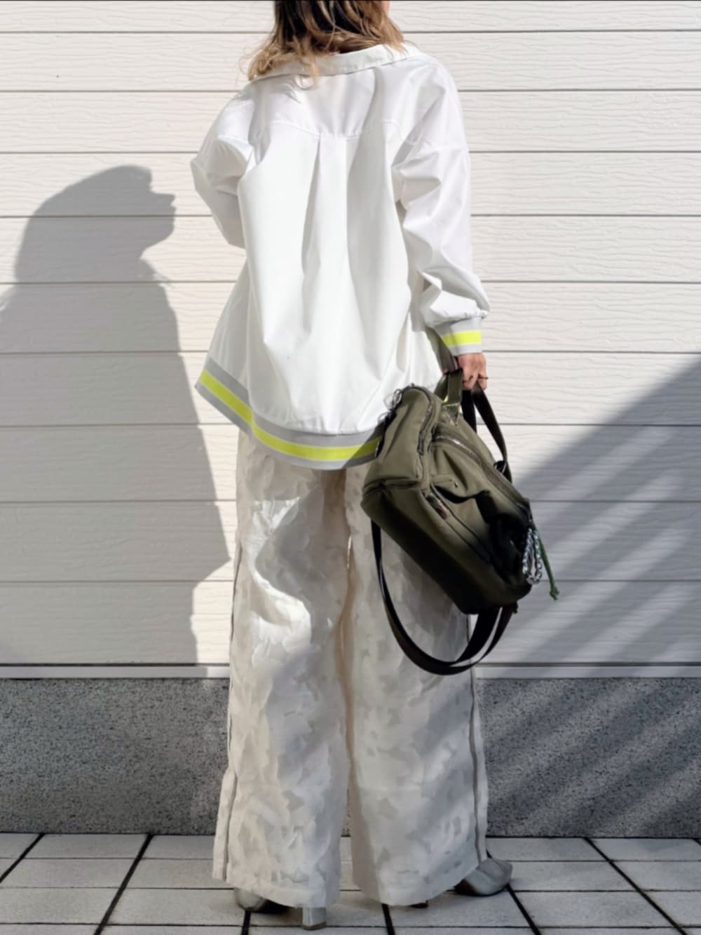 グリーン系のボストンバッグ、ホワイト系のTシャツ/カットソー、ホワイト系のシャツ/ブラウスを着用したレディースの冬コーディネートの3枚目の写真