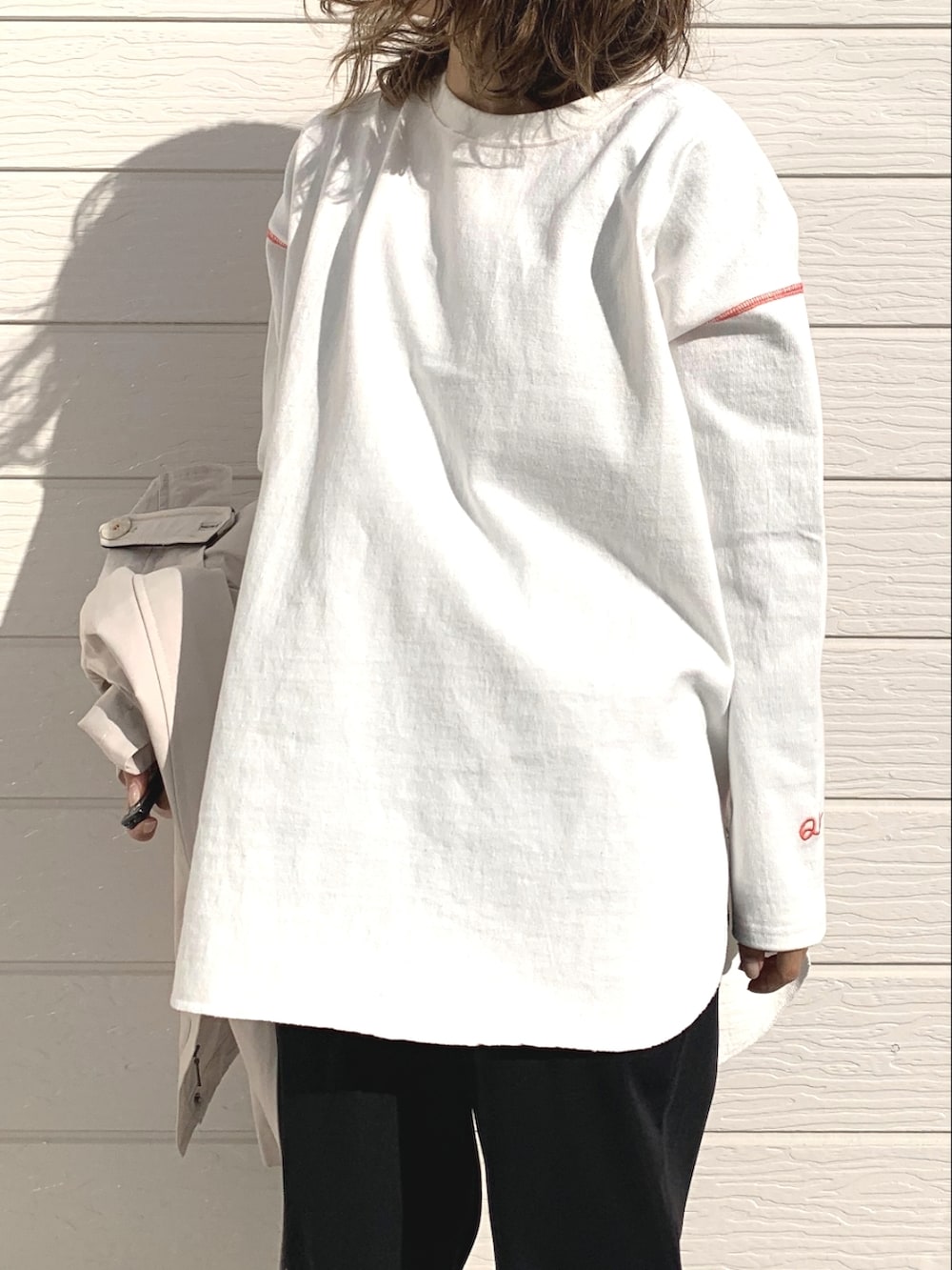 ブラック系のその他パンツ、ホワイト系のTシャツ/カットソー、ベージュ系のその他アウターを着用したレディースの冬コーディネートの3枚目の写真