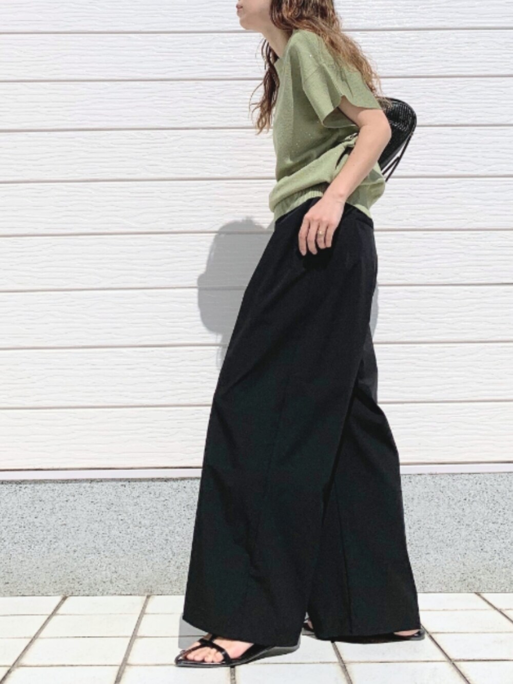 ブラック系のその他パンツ、ブラック系のショルダーバッグ、グリーン系のニット/セーターを着用したレディースの春コーディネートの2枚目の写真