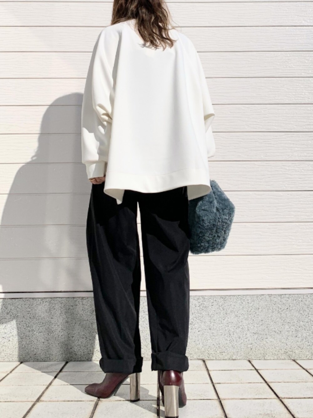 ブラック系のその他パンツ、ブラウン系のブーツ、ブルー系のトートバッグを着用したレディースの秋コーディネートの2枚目の写真