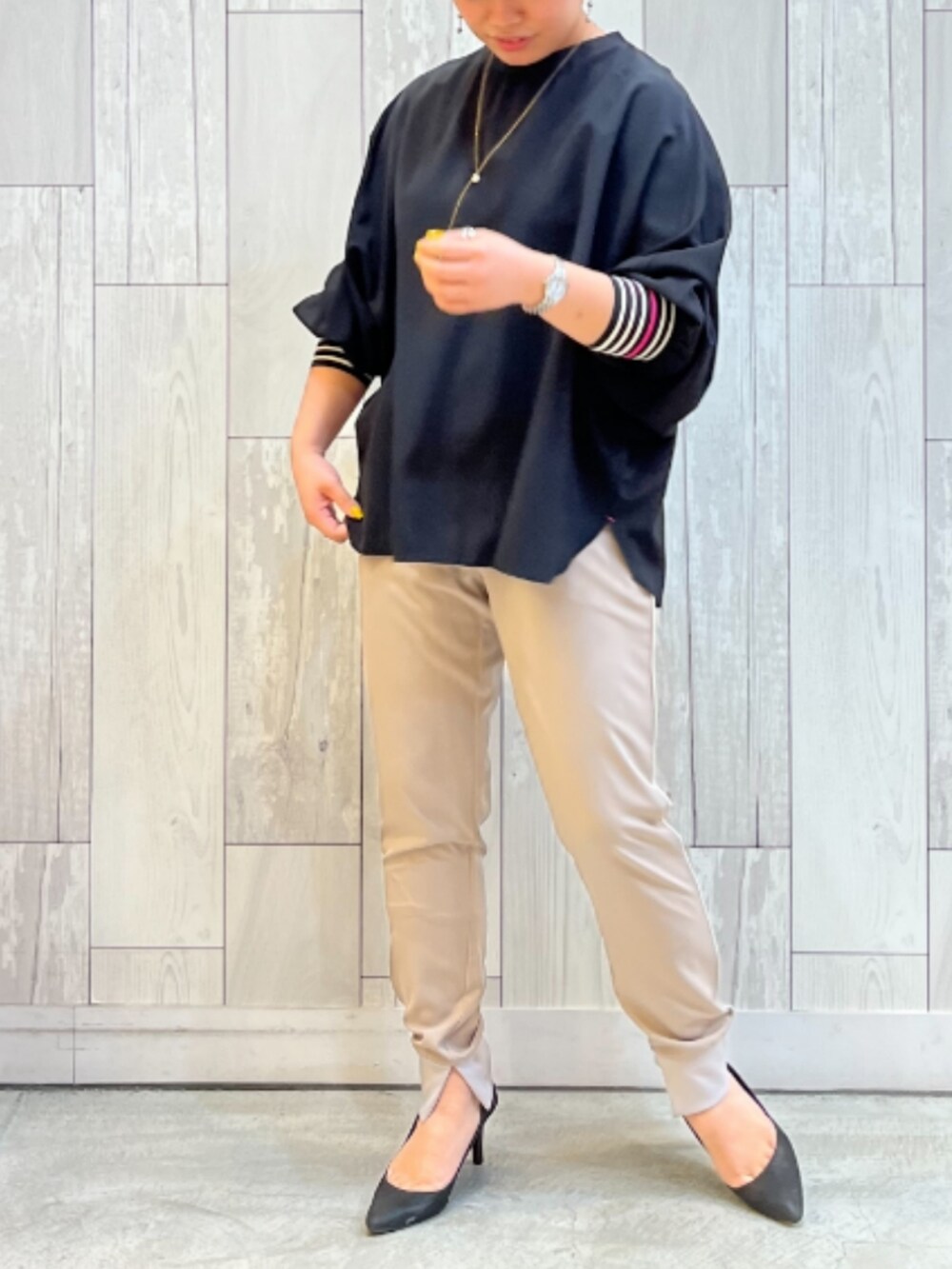 ベージュ系のその他パンツ、ブラック系のシャツ/ブラウス、ゴールド系のネックレスを着用したレディースの春コーディネートの2枚目の写真