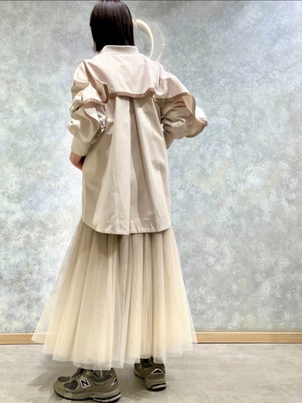 ゴールド系のスカート、ベージュ系のブルゾン、ホワイト系のTシャツ/カットソーを着用したレディースの冬コーディネートの3枚目の写真