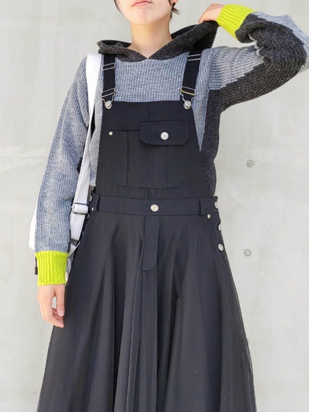 ホワイト系のバックパック/リュック、グレー系のニット/セーター、ブラック系のジャンパースカートを着用したレディースの秋コーディネートの3枚目の写真