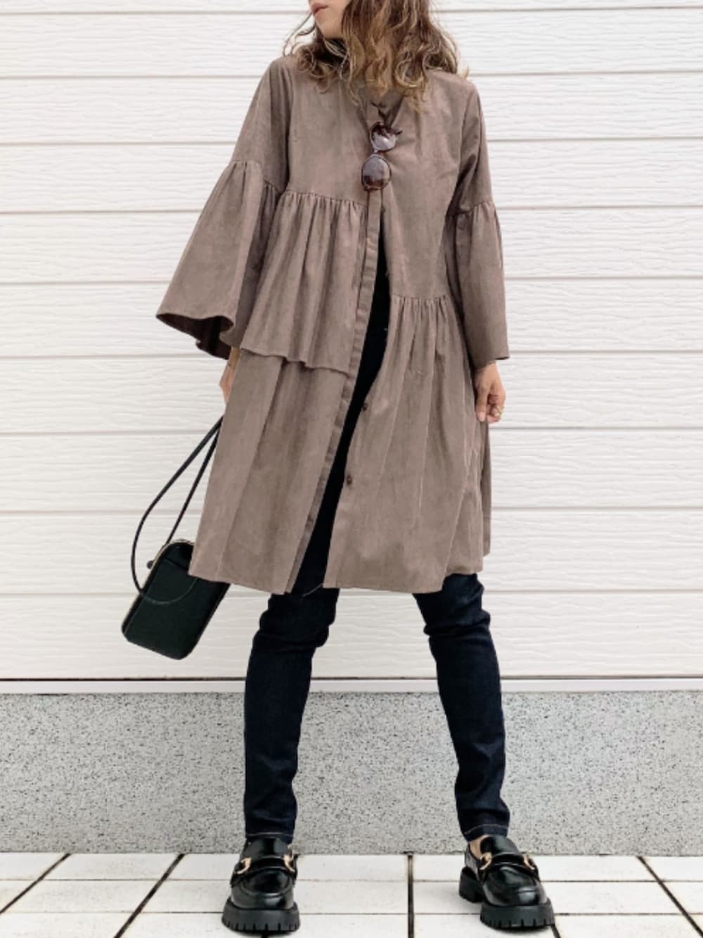 ブルー系のデニムパンツ、ブラック系のローファー、ブラック系のショルダーバッグを着用したレディースの秋コーディネートの2枚目の写真