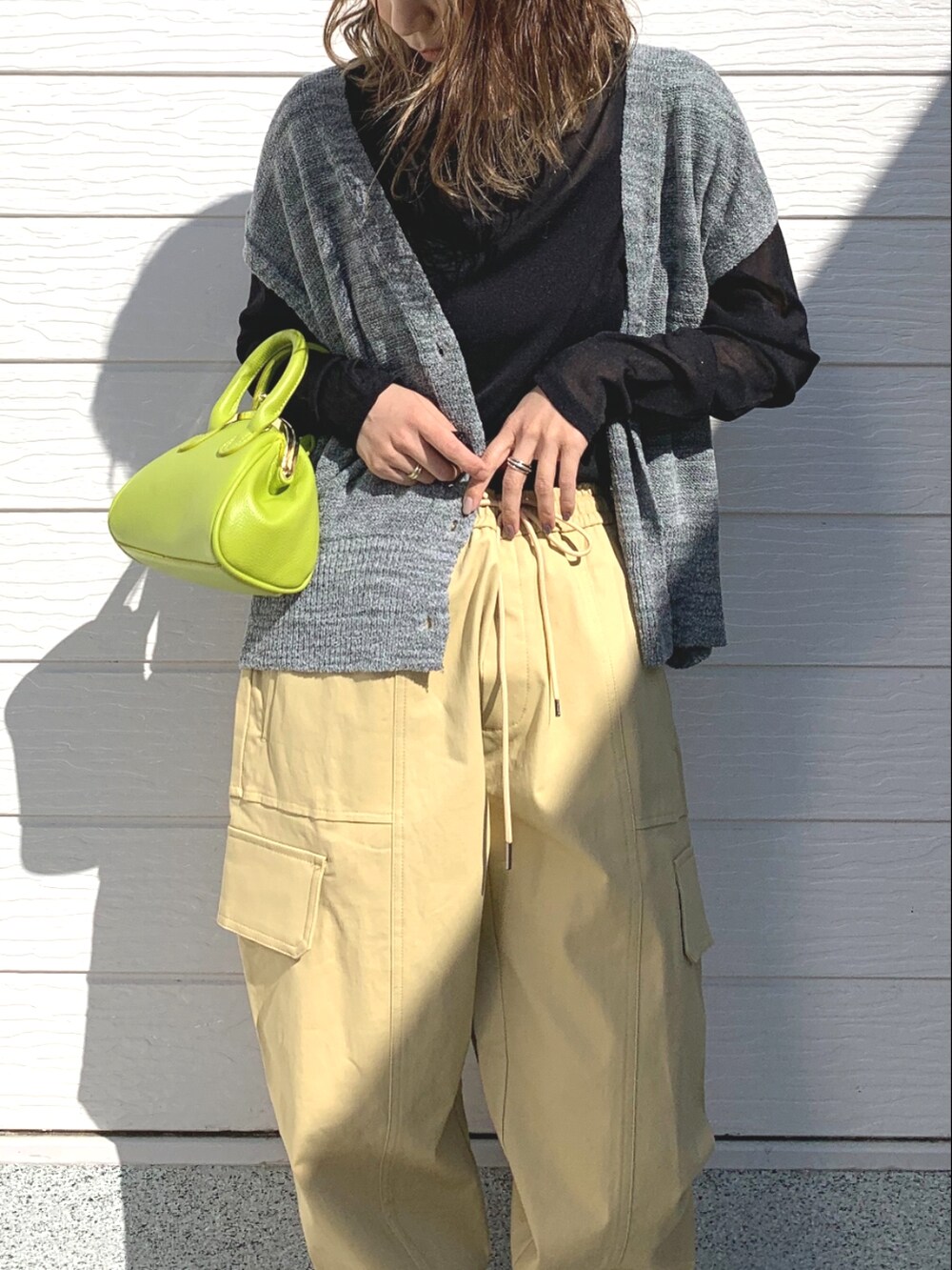 ベージュ系のその他パンツ、グリーン系のショルダーバッグ、ブラック系のTシャツ/カットソーを着用したレディースの春コーディネートの4枚目の写真