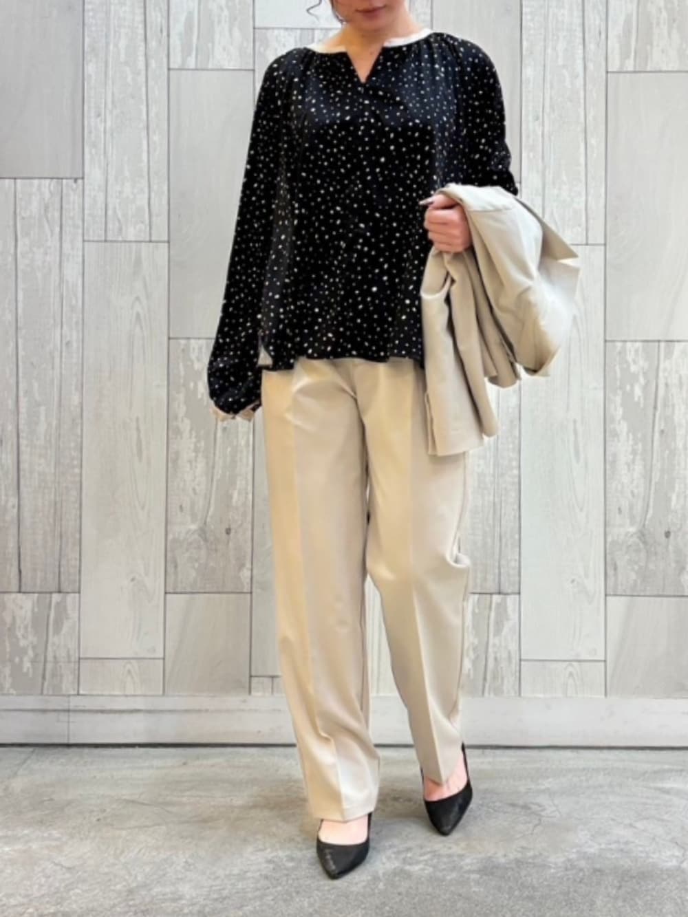 ベージュ系のスラックス、ベージュ系のテーラードジャケット、ブラック系のシャツ/ブラウスを着用したレディースの春コーディネートの3枚目の写真