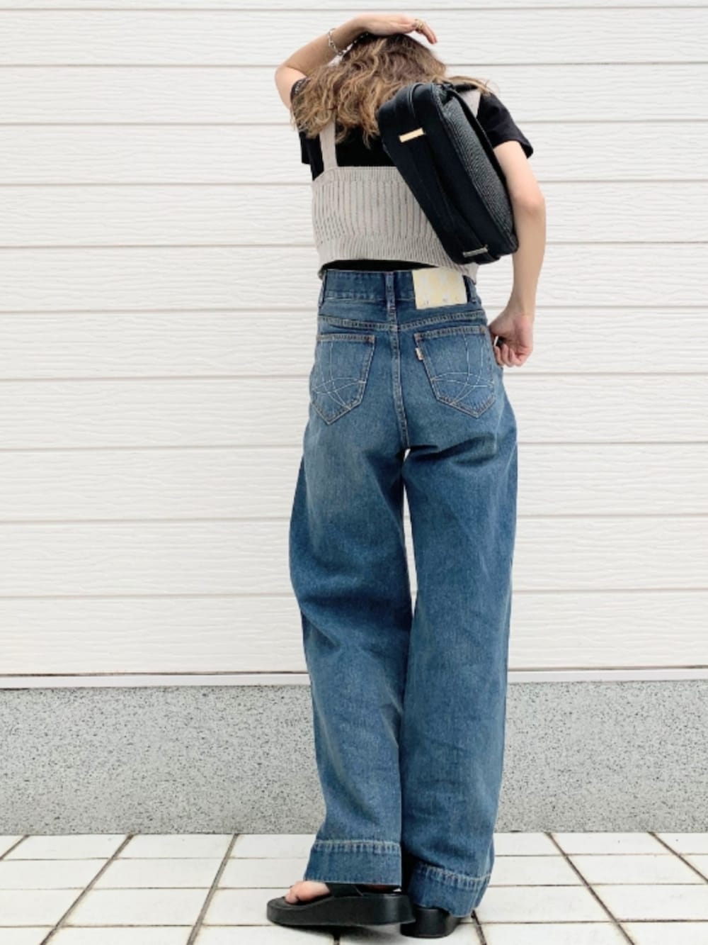 ブラック系のTシャツ/カットソー、ブラック系のショルダーバッグ、グレー系のベストを着用したレディースの春コーディネートの3枚目の写真