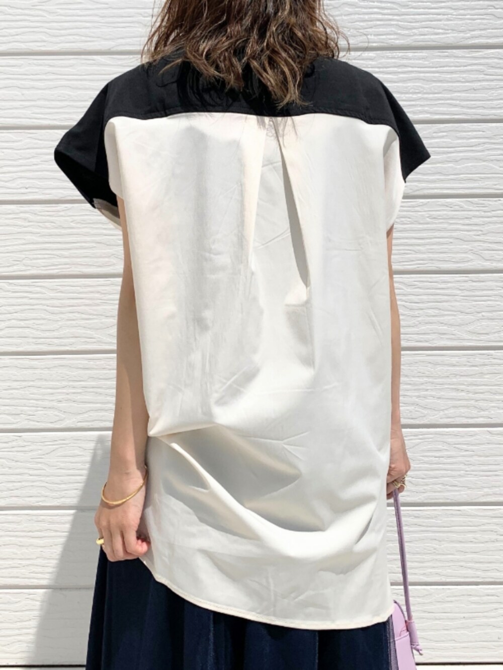 パープル系のショルダーバッグ、ブラック系のサンダル、ブルー系のスカートを着用したレディースの春コーディネートの4枚目の写真