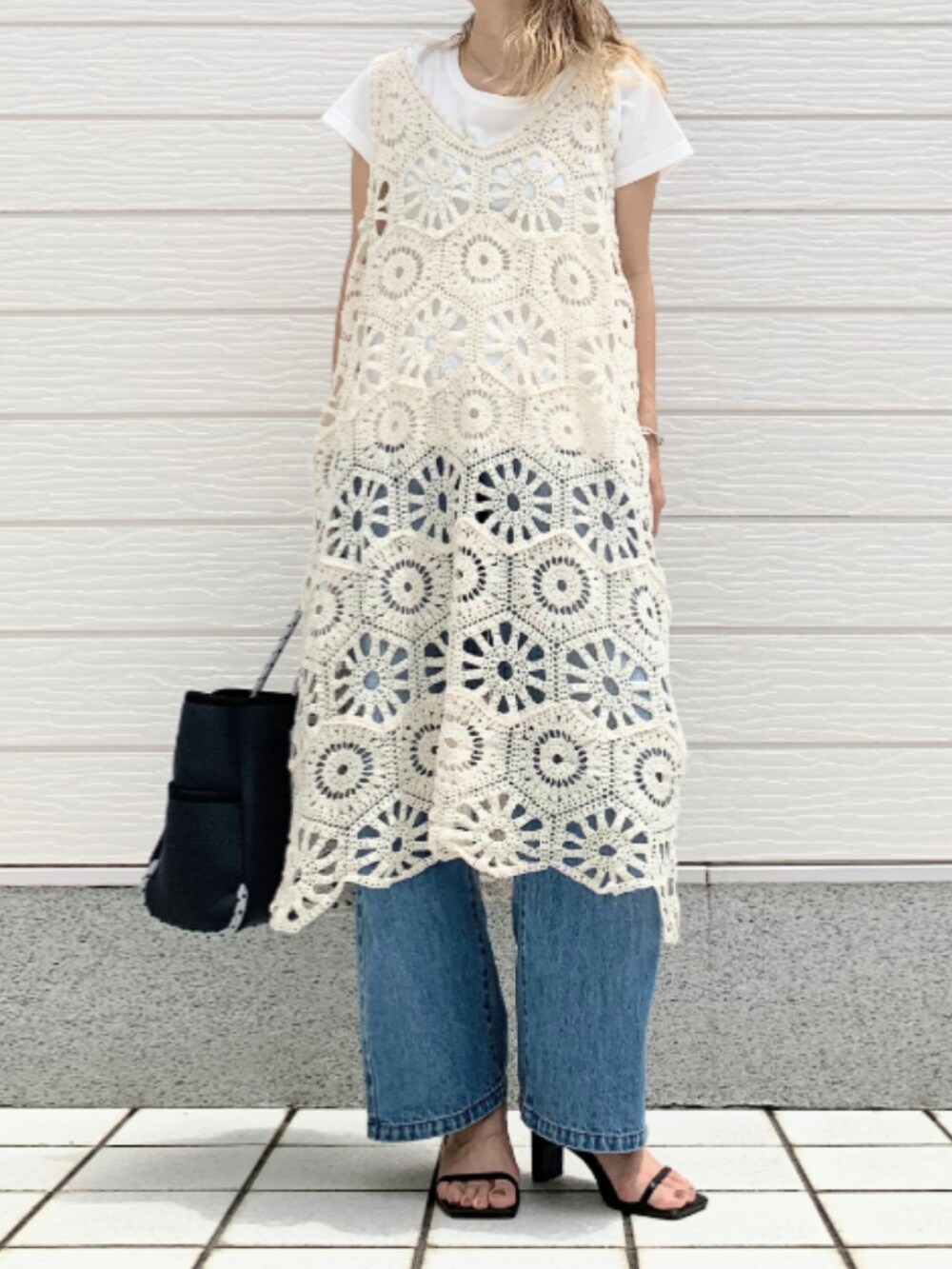 ブルー系のデニムパンツ、ブルー系のトートバッグ、ホワイト系のワンピースを着用したレディースの夏コーディネートの2枚目の写真