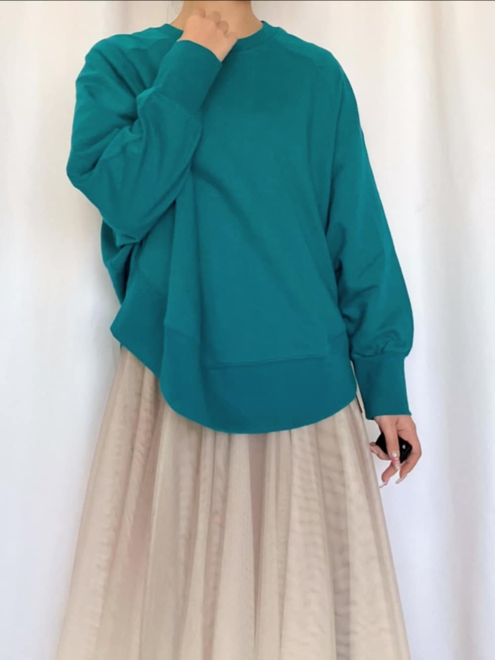 ゴールド系のスカート、グリーン系のスウェット、シルバー系のスニーカーを着用したレディースの冬コーディネートの3枚目の写真