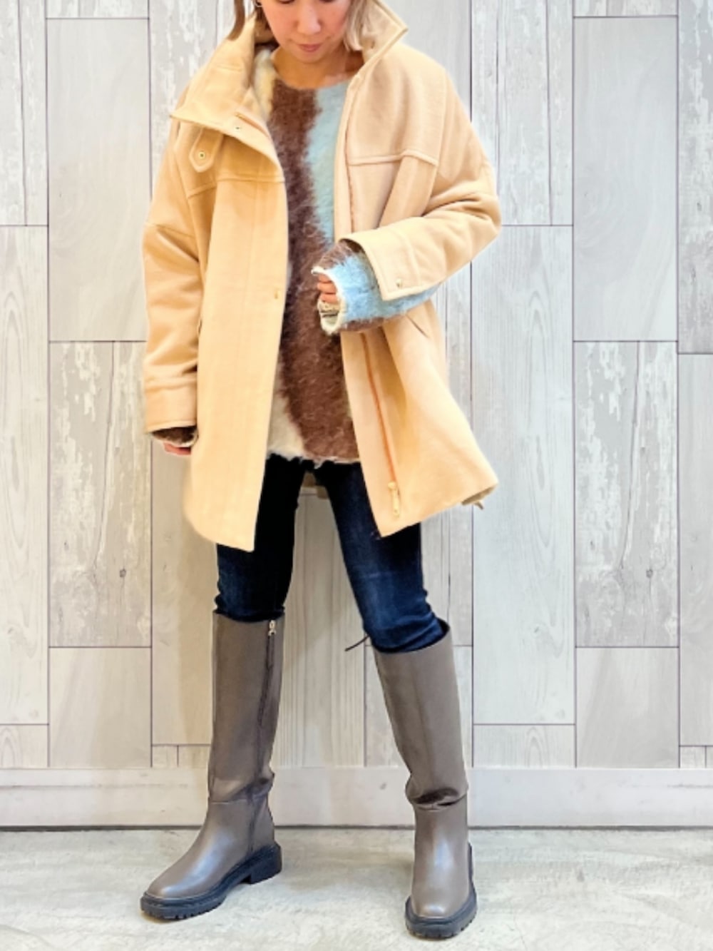 ブルー系のデニムパンツ、グレー系のブーツ、ブルー系のニット/セーターを着用したレディースの冬コーディネートの2枚目の写真