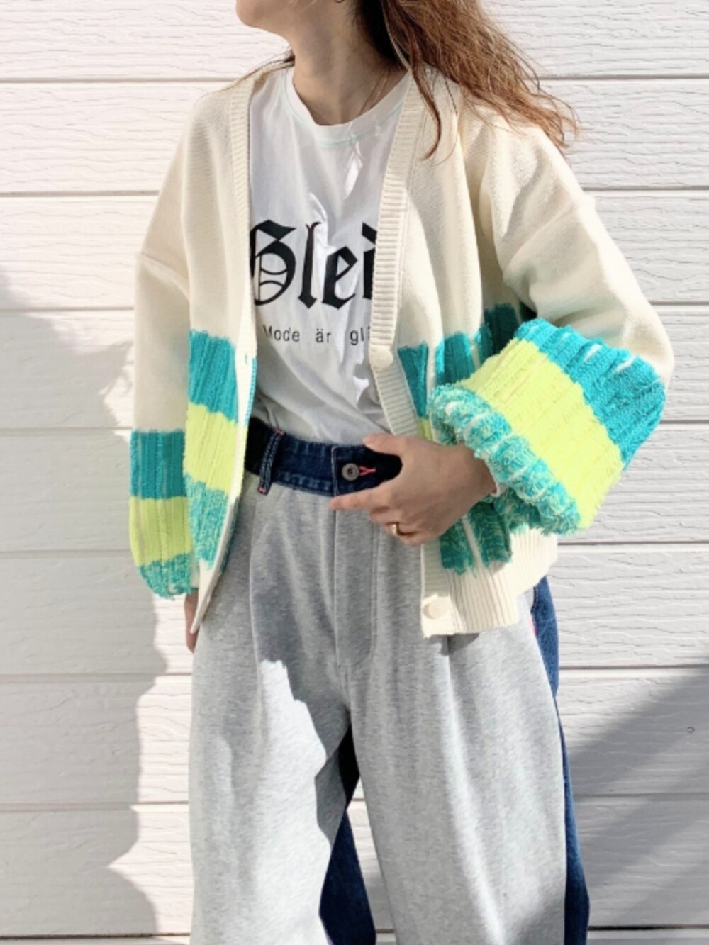 グレー系のデニムパンツ、ホワイト系のスニーカー、ホワイト系のTシャツ/カットソーを着用したレディースの冬コーディネートの5枚目の写真