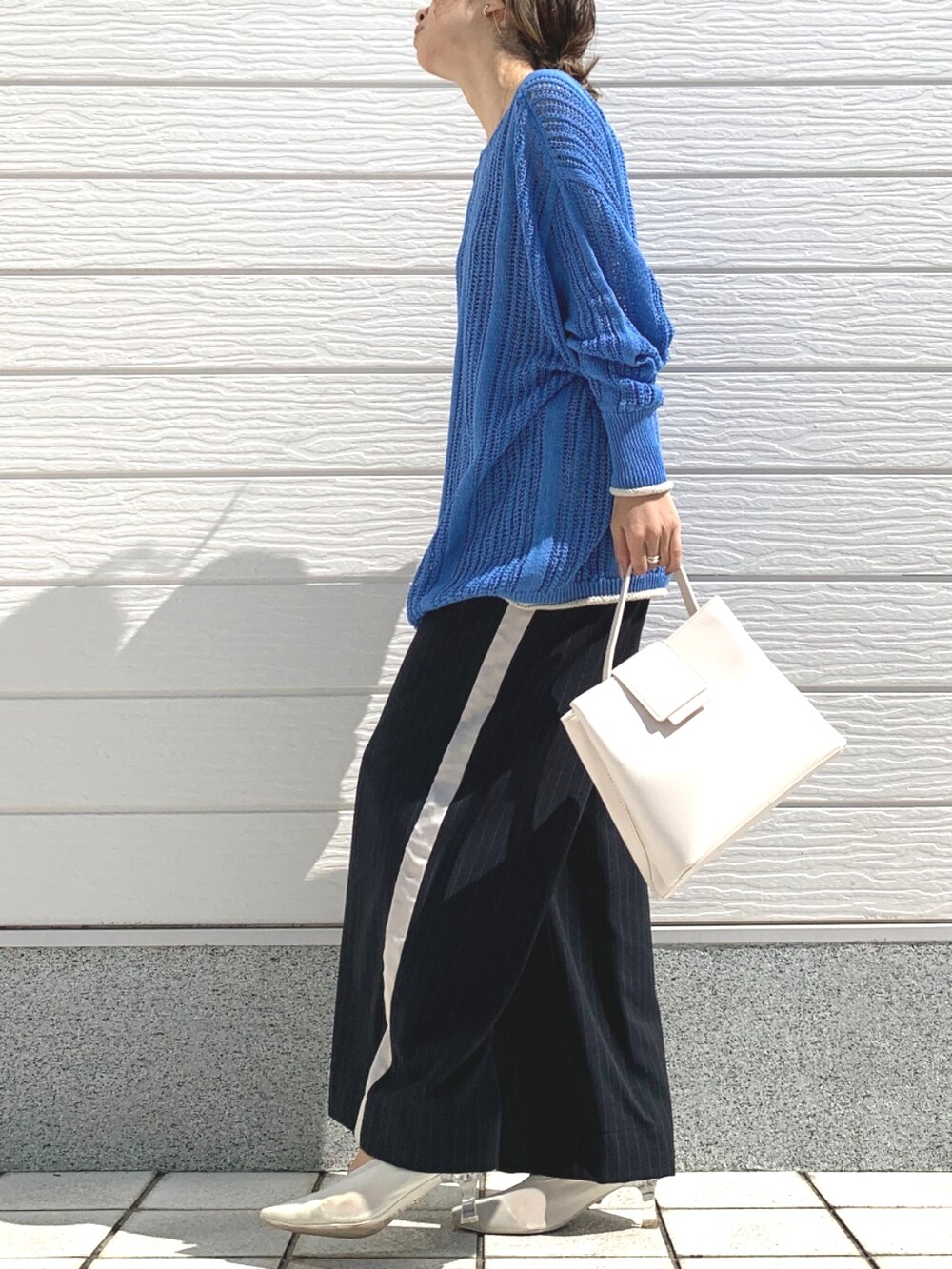 ホワイト系のハンドバッグ、ブルー系のその他パンツ、ブルー系のニット/セーターを着用したレディースの春コーディネートの2枚目の写真