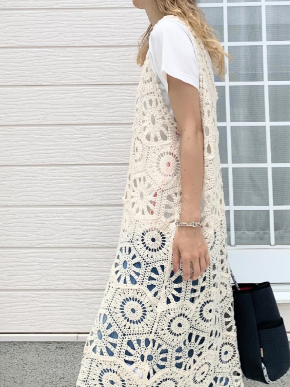 ブルー系のデニムパンツ、ブルー系のトートバッグ、ホワイト系のワンピースを着用したレディースの夏コーディネートの4枚目の写真