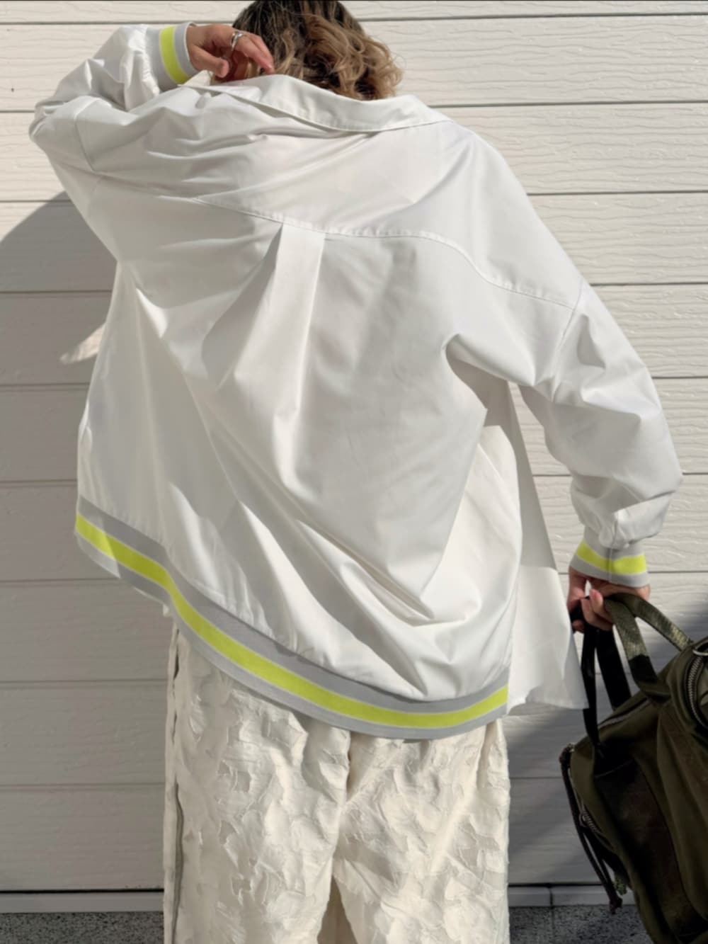 グリーン系のボストンバッグ、ホワイト系のTシャツ/カットソー、ホワイト系のシャツ/ブラウスを着用したレディースの冬コーディネートの5枚目の写真