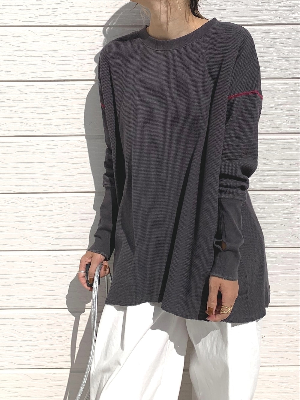 ホワイト系のデニムパンツ、シルバー系のショルダーバッグ、シルバー系のスニーカーを着用したレディースの秋コーディネートの2枚目の写真