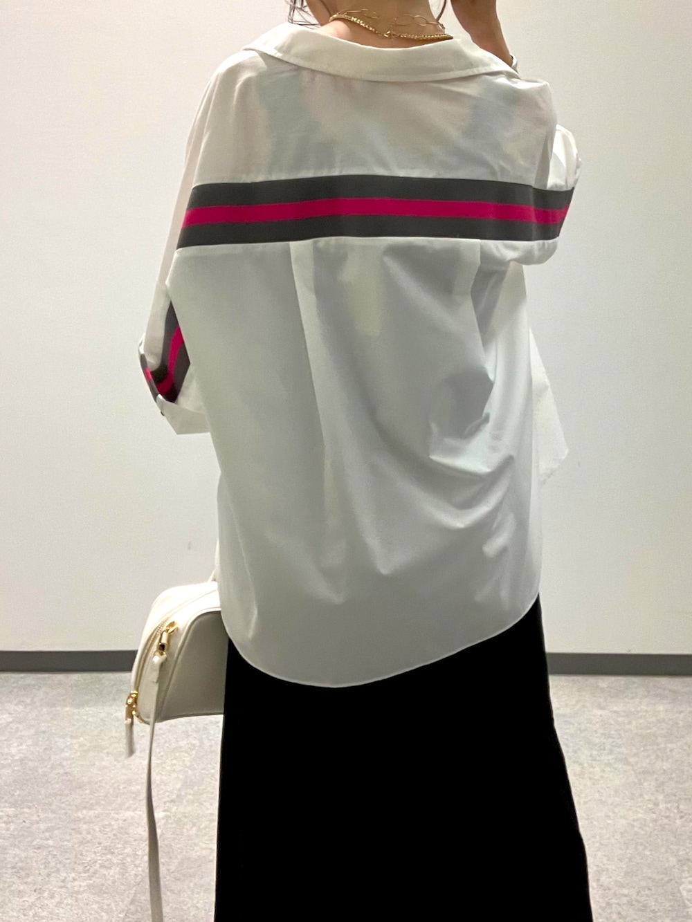 ブラック系のデニムスカート、ホワイト系のシャツ/ブラウスを着用したレディースの夏コーディネートの4枚目の写真