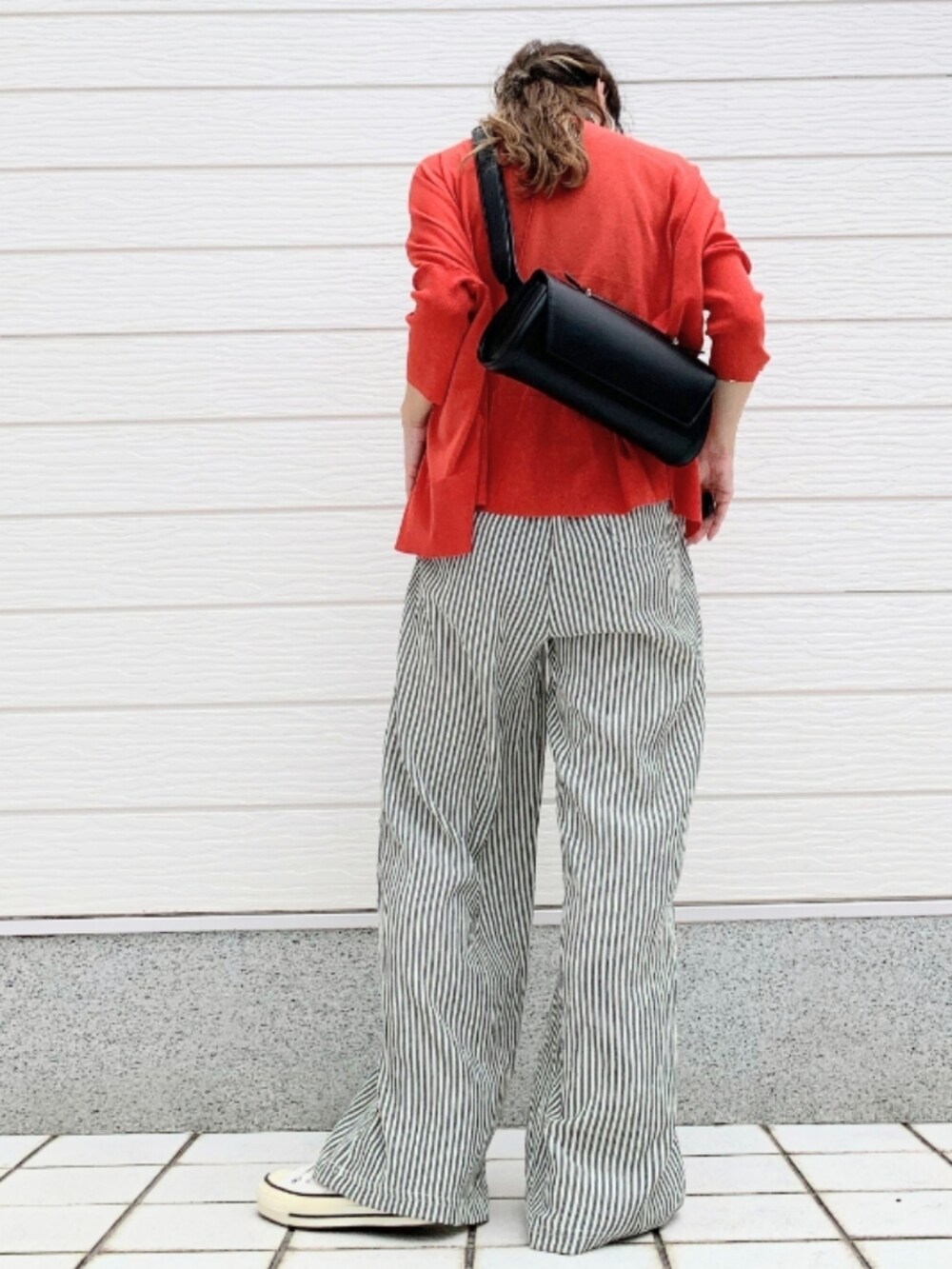 ホワイト系のスニーカー、レッド系のカーディガン/ボレロ、ベージュ系のタンクトップを着用したレディースの夏コーディネートの3枚目の写真