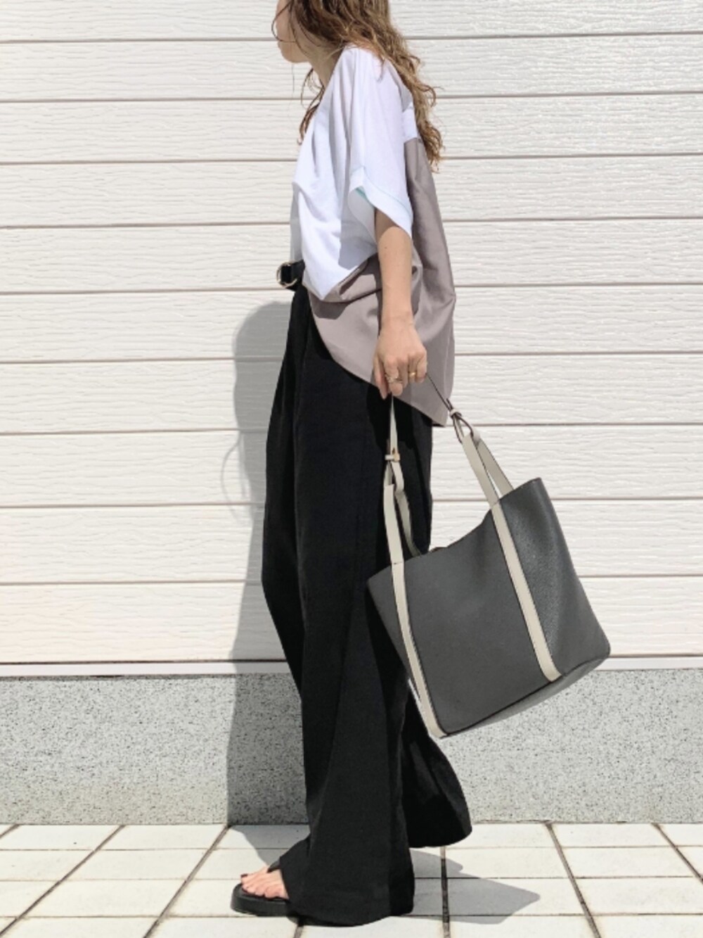 ブラック系のその他パンツ、グレー系のトートバッグ、ホワイト系のTシャツ/カットソーを着用したレディースの春コーディネートの2枚目の写真