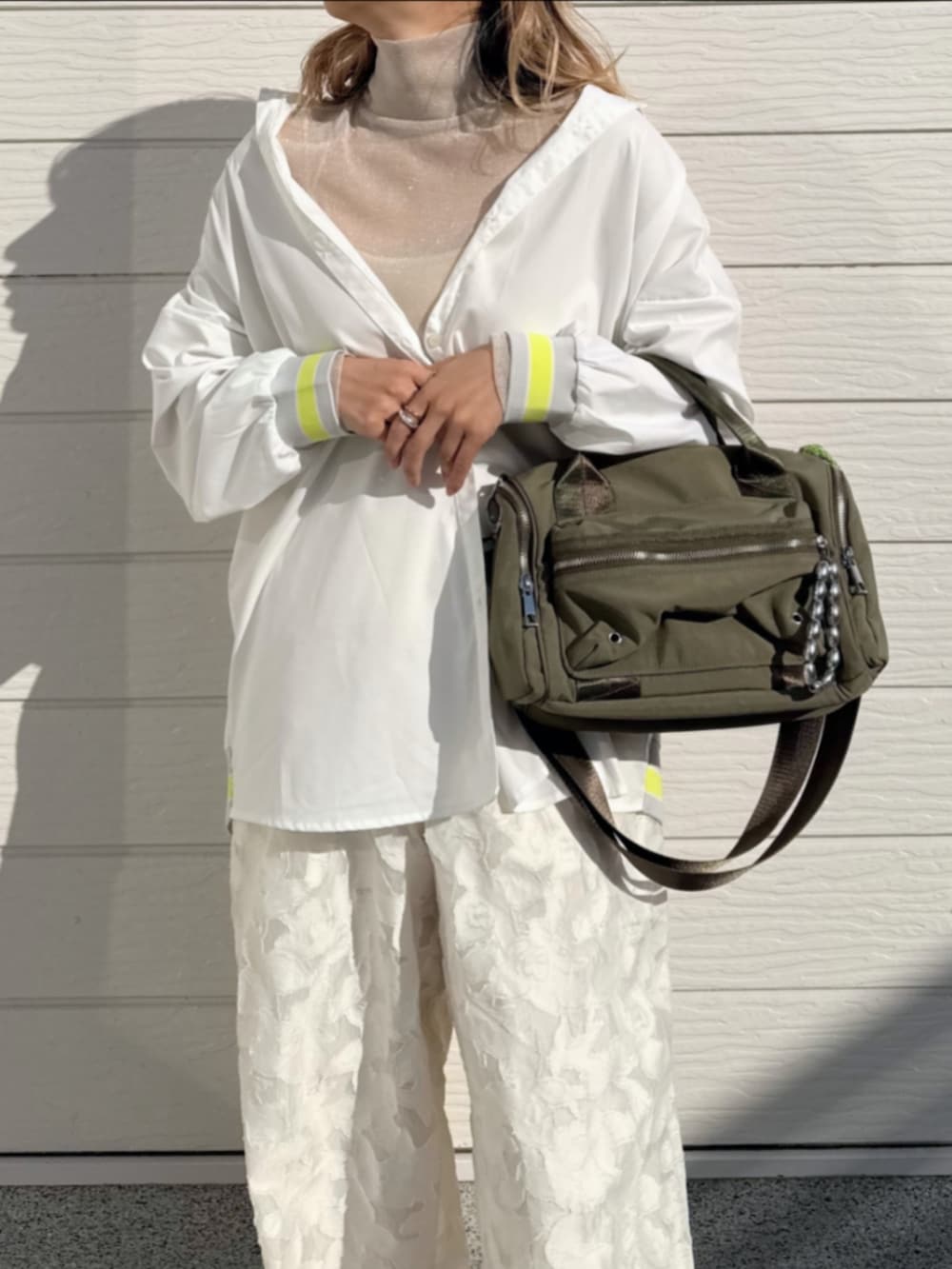 グリーン系のボストンバッグ、ホワイト系のTシャツ/カットソー、ホワイト系のシャツ/ブラウスを着用したレディースの冬コーディネートの4枚目の写真